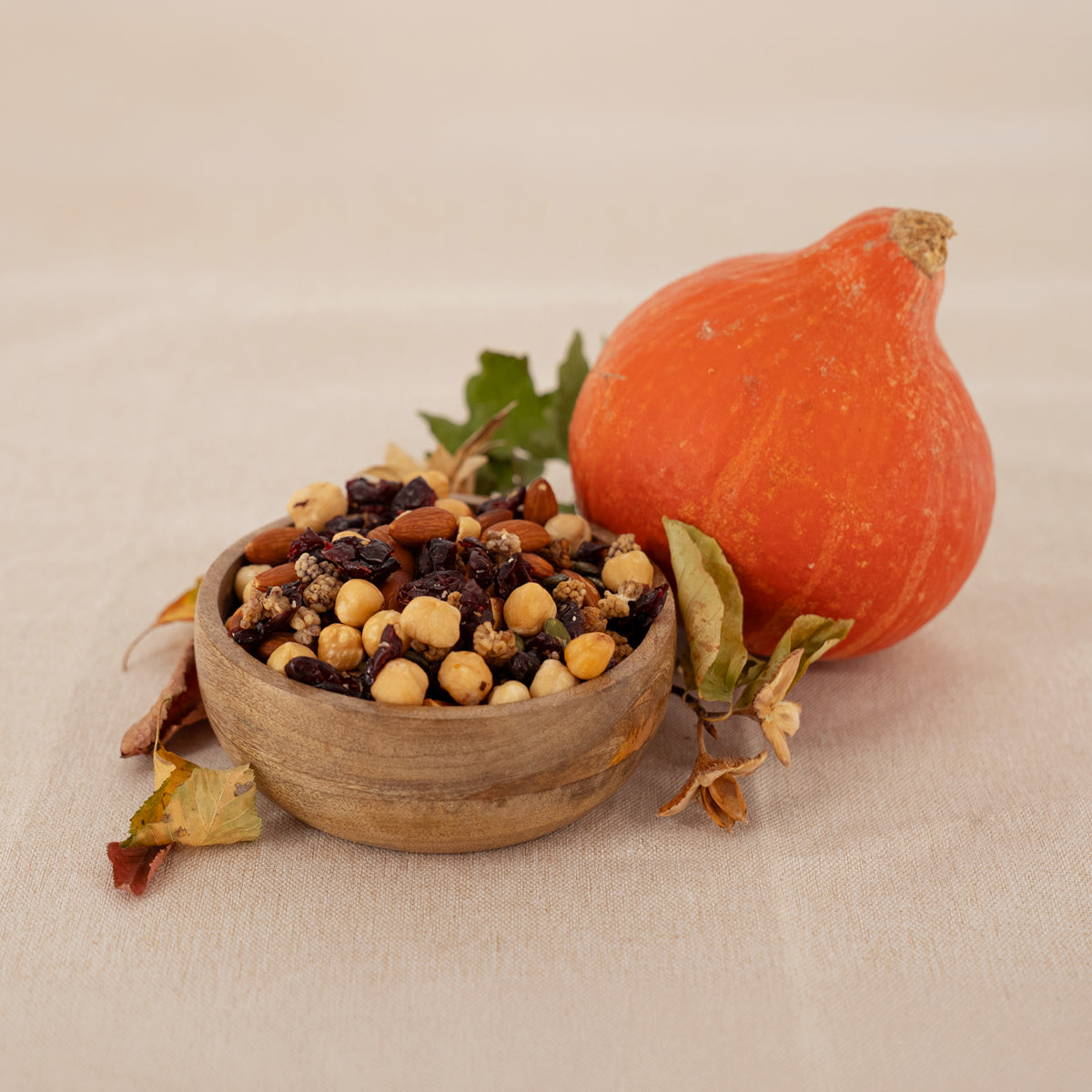 Nussmischung goldener Herbst mit Mandeln, Haselnüssen, Kürbiskernen, Cranberries, Maulbeeren in Holzschale