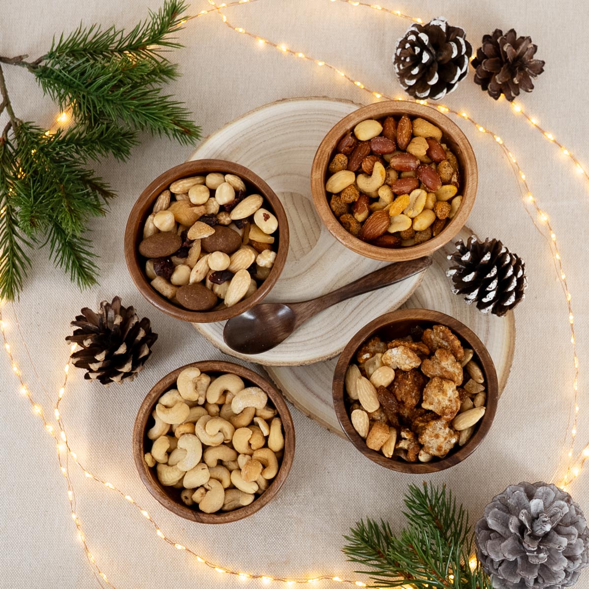 Nussmischungen und geröstete Nüsse in Holzschalen und mit weihnachtlicher Deko