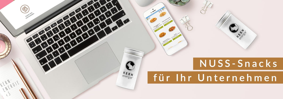 Lecker KERNenergie Nüsse in der personalisierbaren recyclebaren Aludose über einem Laptop am Arbeitsplatz. Angebot für Unternehmen.