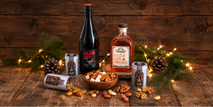 Glühwein und Glüh Gin mit weihnachtlichen Aludosen und Nüssen auf einem Holztisch