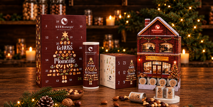 Vier Adventskalendern auf einem Holztisch mit Weihnachtsdeko
