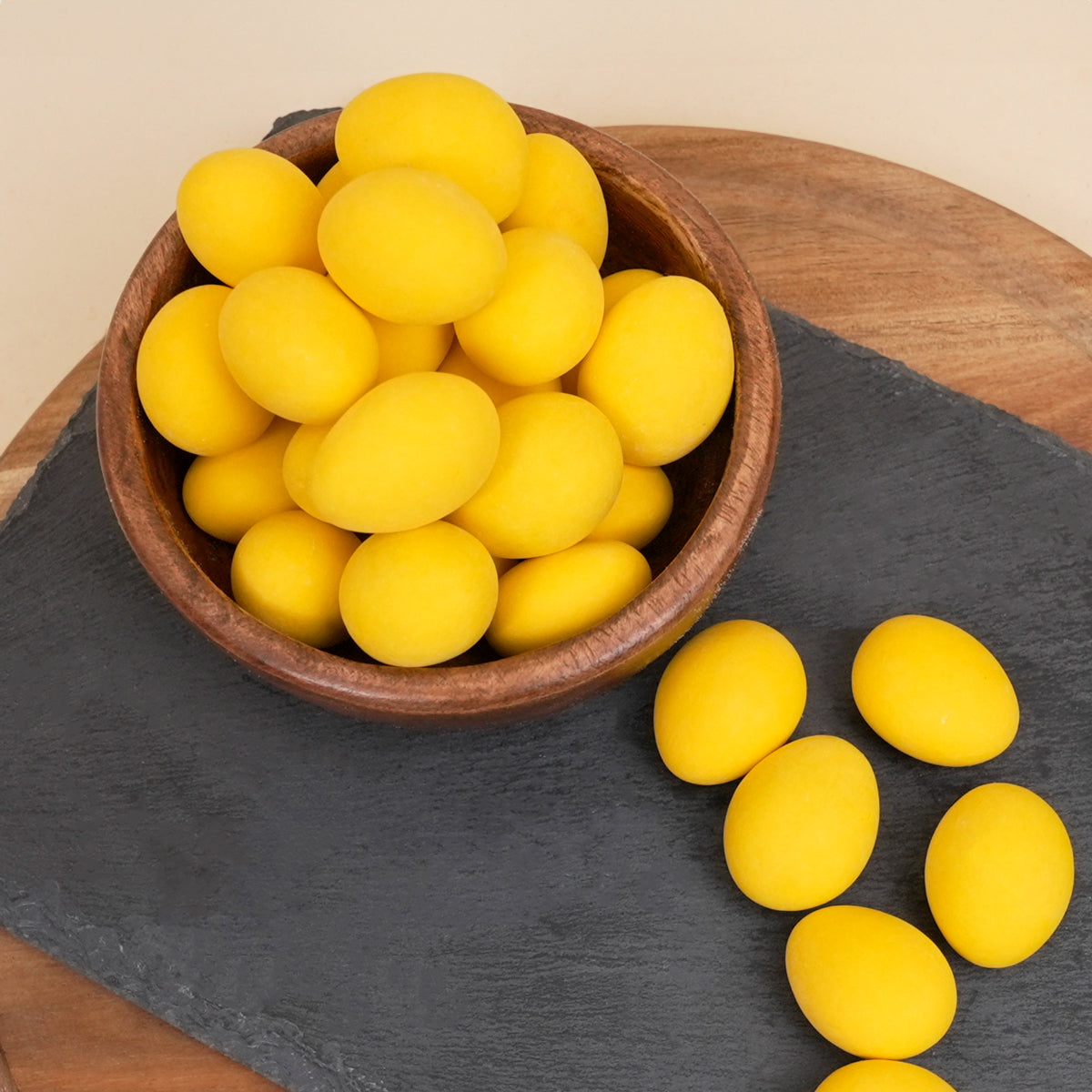 Schokolierte Limoncello-Mandeln in Holzschale und auf Tablett arrangiert 