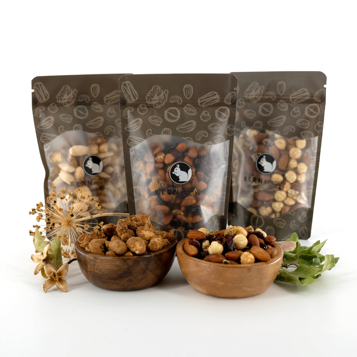 Nussmischungen und gebrannte Cashewkerne in Holzschalen und KERNenergie Snackbeuteln
