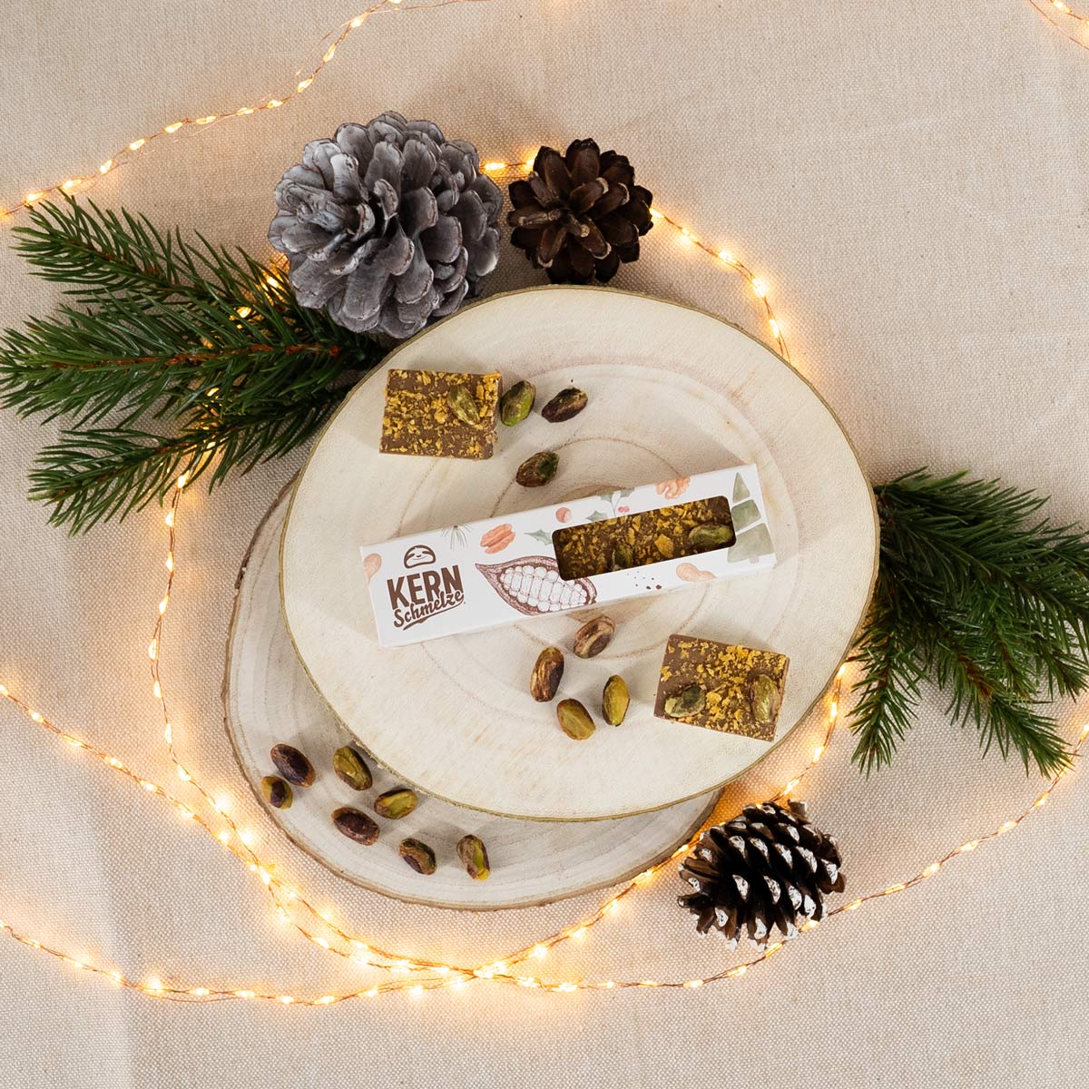 Schokoladenriegel mit Vollmilchschokolade und weißer Schokolade mit gerösteten Pistazien, Aprikosenstückchen und Pistaziencremefüllung in weihnachtlicher Verpackung